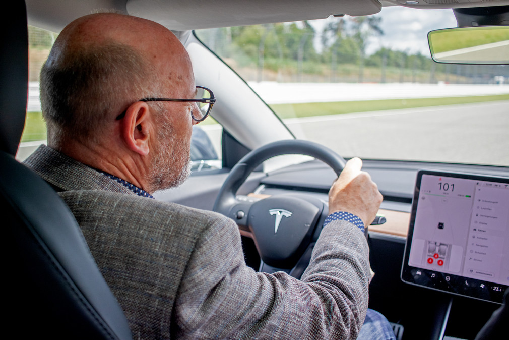 Verkehrsminister Winfried Hermann MdL bei der Probefahrt im Tesla Model 3 beim e4 TESTIVAL 2019 (Bilderquelle: Kira Chaparro_© emodrom)