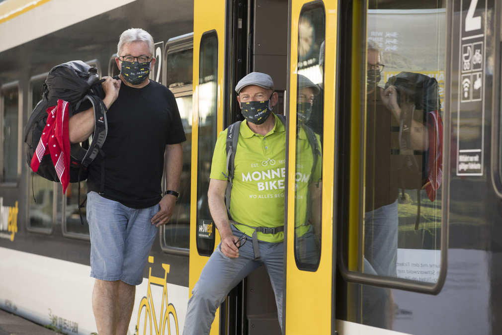 Winfried Hermann, Guido Wolf am Bahnsteig mit Masken in Freizeitkleidung