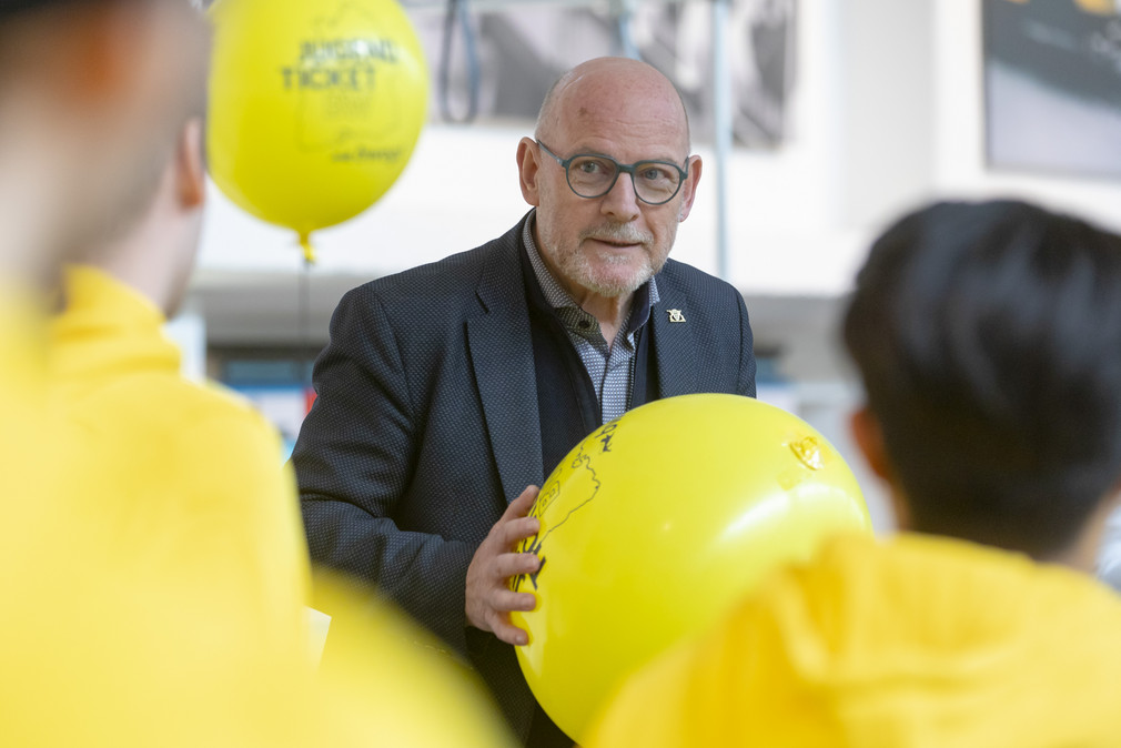 Minister Hermann mit einem gelben JugendticketBW-Luftballon in der Hand.