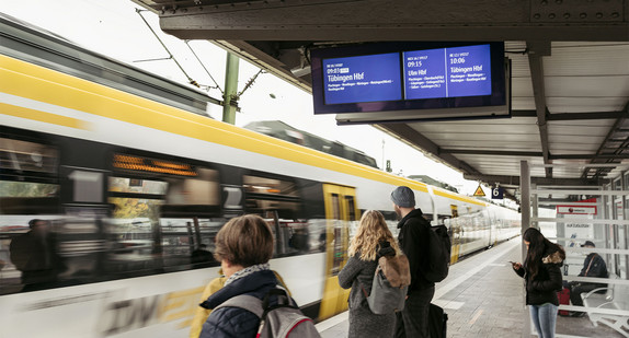 Ein Zug fährt an einem Bahnsteig ein.
