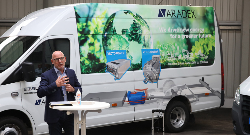 Verkehrsminister Winfried Hermann spricht vor einem E-Lkw von ARADEX
