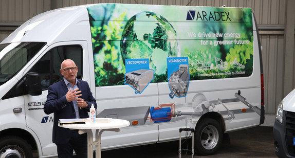 Verkehrsminister Winfried Hermann spricht vor einem E-Lkw von ARADEX