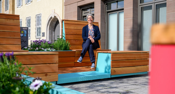 Staatssekretärin sitzt auf Mobililar zum beleben von Ortsmitten. 