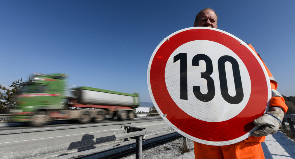 Straßenwärter hält an der Autobahn A81 am Hegaublick ein Schild mit der Aufschrift 130 in den Händen. Ziel ist es, illegale Autorennen zu verhindern. Bild: Patrick Seeger/dpa
