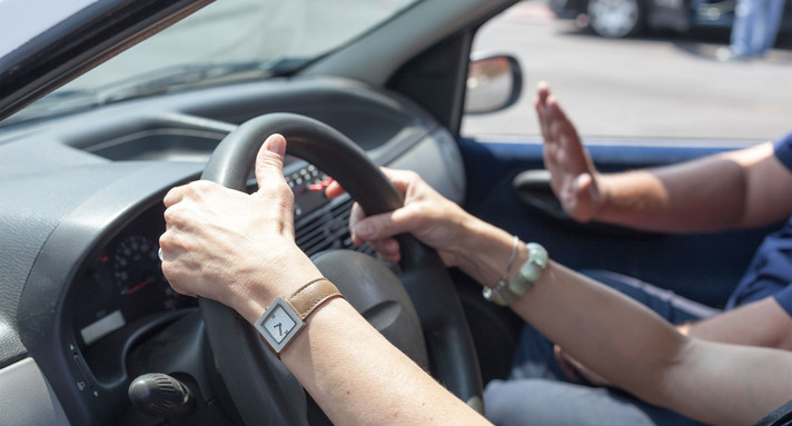 Zwei Hände halten das Lenkrad eines Autos