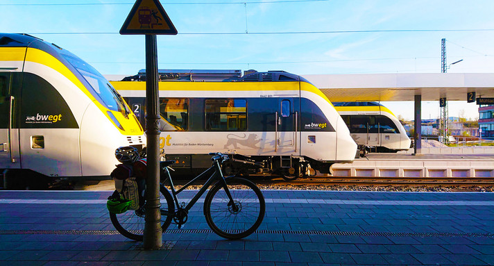 An einem Bahnhof stehen versetzt nebeneinander drei verschiedene Züge.