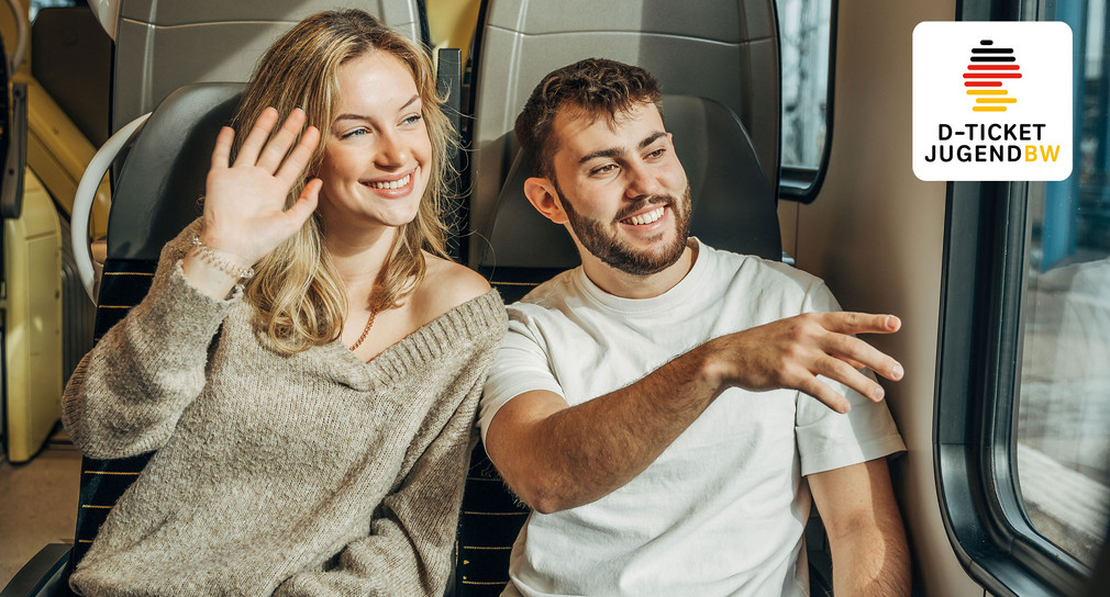 Eine junge Frau und ein junger Mann sitzen lächelnd im Zug. In der Ecke rechts oben ist das Logo des D-Ticket JugendBW abgebildet..