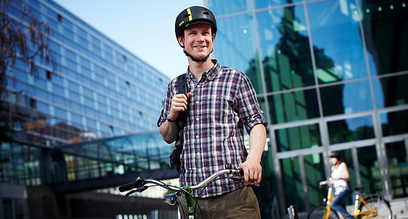 Mann mit Helm sitzt auf einem Fahrrad.