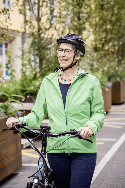 Staatssekretärin Elke Zimmer trägt einen Fahrradhelm und schiebt ihr Fahrrad.