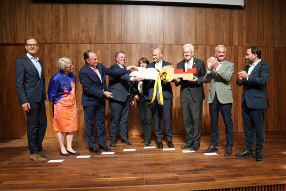 Europa Erweiterungsbau für Landesvertretung in Brüssel übergeben Gruppenbild auf der Bühne: Symbolische Schlüsselübergabe durch Ministerpräsident Winfried Kretschmann