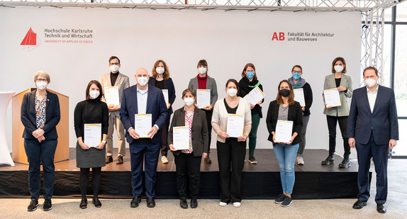 Mehrere Frauen und Männer stehen zu einem Gruppenbild zusammen und zeigen ein Zertifikat in die Kamera.