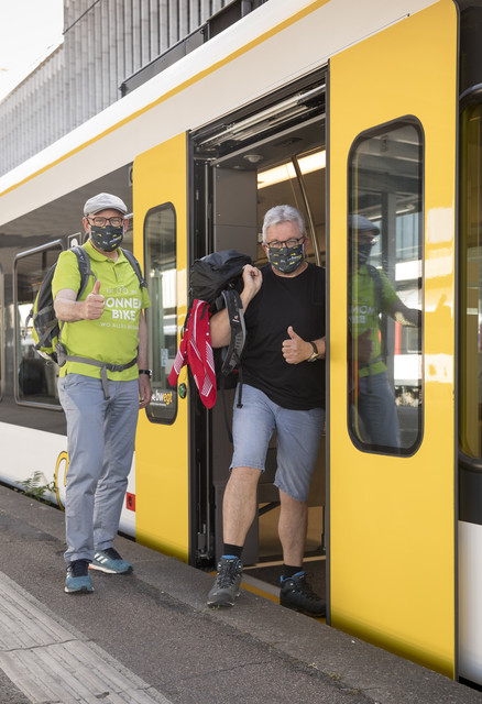 Winfried Hermann, Guido Wolf am Bahnsteig mit Masken in Freizeitkleidung