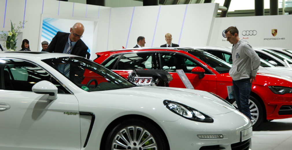 Besucher auf der i-mobility 2014 in Stuttgart betrachten einen Plug-in Hybriden von Porsche.