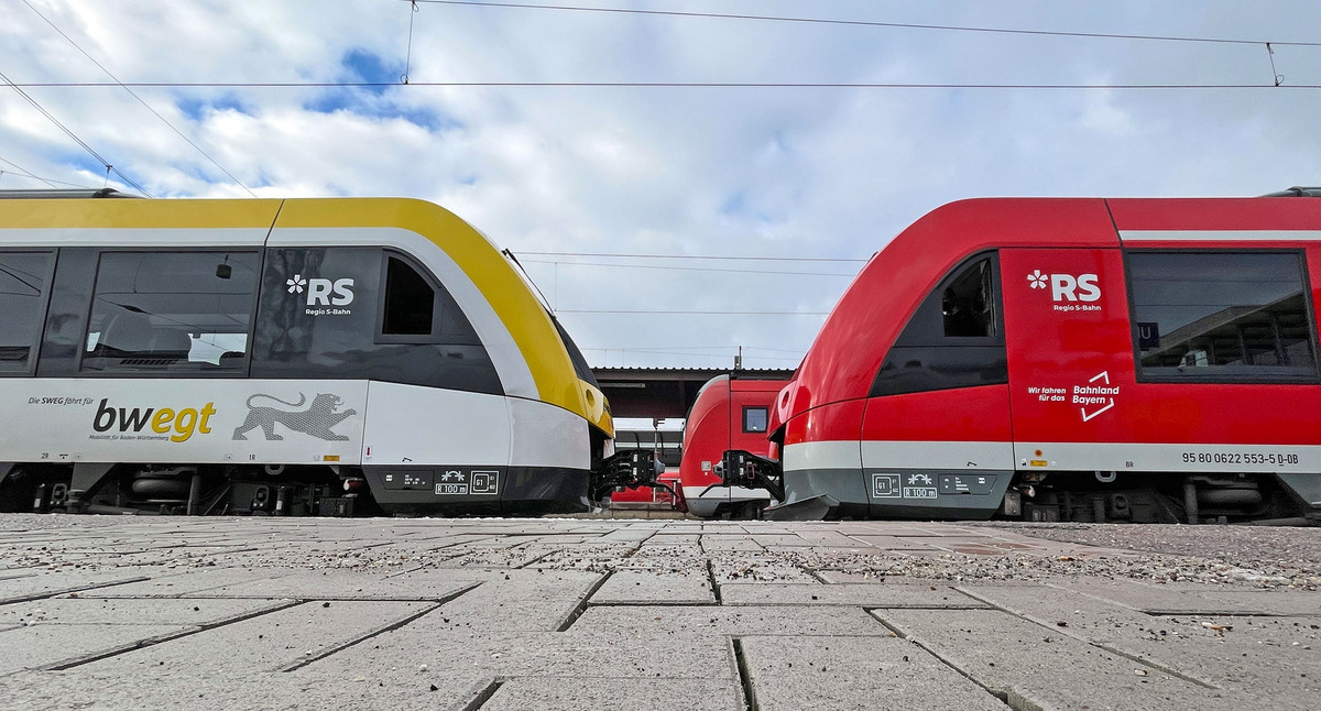Zwei Züge stehen sich an einem Bahnsteig gegenüber.