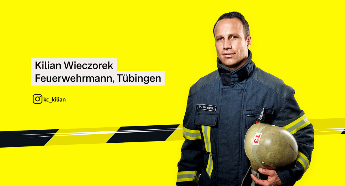 Porträtfoto von Feuerwehrmann Kilian Wieczorek in Einsatzkleidung. Unter dem Arm hält einen Feuerwehrhelm.