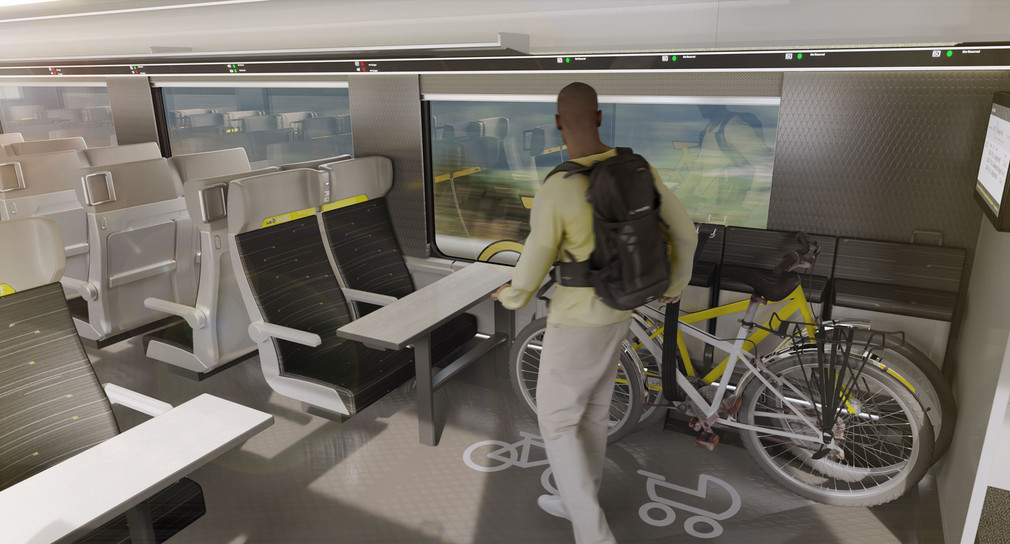 Ein Mann stellt ein Fahrrad in einem dafür vorgesehenen Bereich in einem Zug ab.