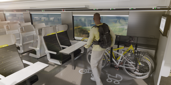 Bahn Neue Doppelstockzüge von Alstom Ein Mann stellt ein Fahrrad in einem dafür vorgesehenen Bereich in einem Zug ab.
