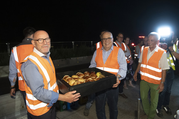 Minister Hermann übergibt Georg Sariyannis (Technischer Leiter Tiefbau, Baugruppe Gross) Verpflegung für die Bauarbeiter vor Ort.  