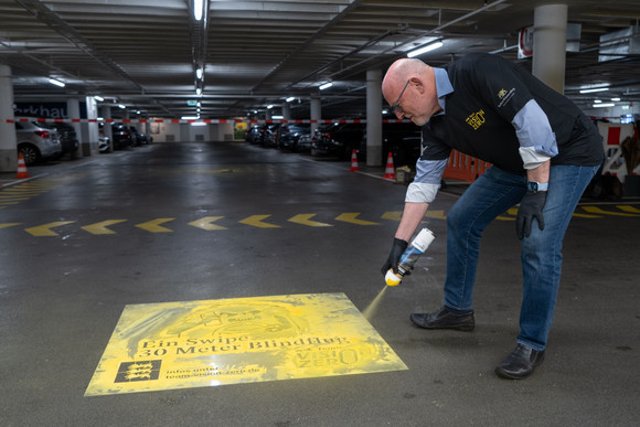 Minister Hermann trägt Sprühbild auf
