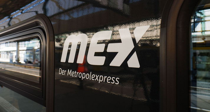 An der Seite eines Zuges klebt das Logo der Metropolexpress-Züge.
