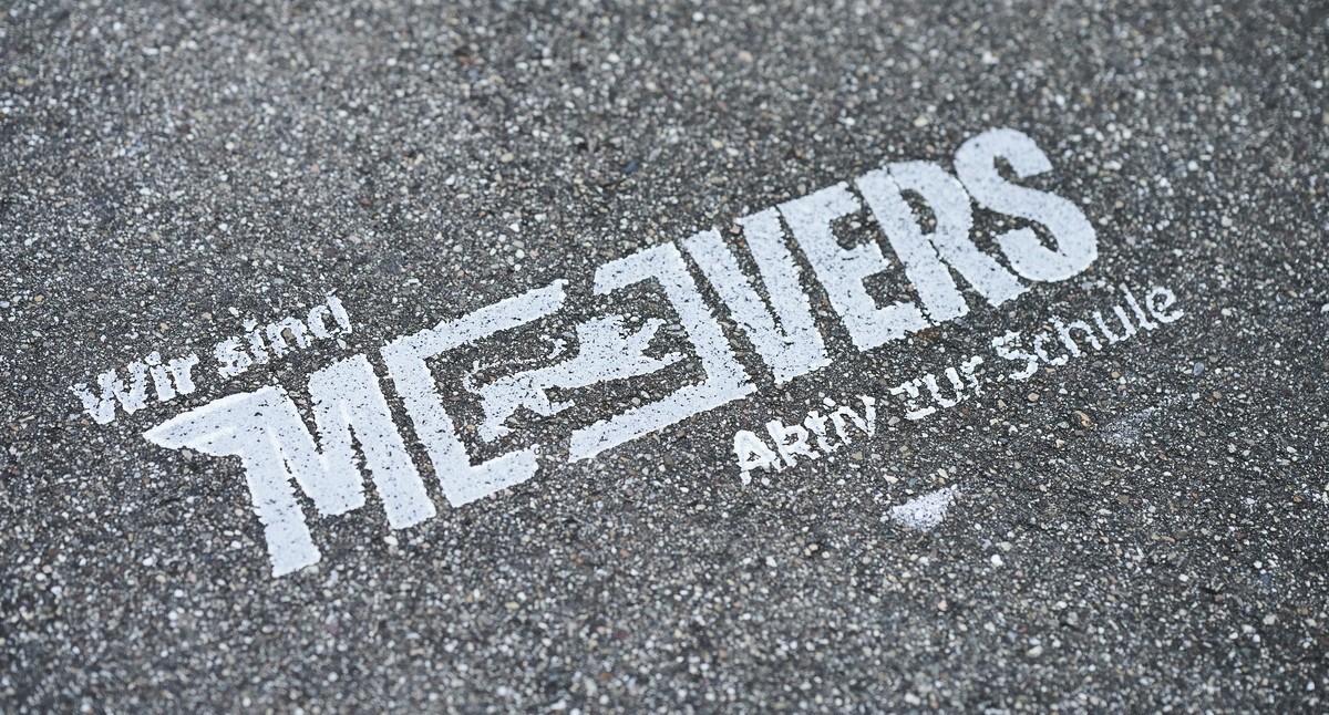 Auf Aspahlt das Logo des Landesprogramms: Wir sind MOVERS – AKtiv zur Schule