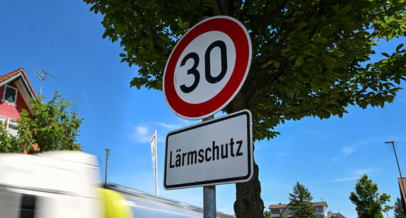 Tempo 30 Schild an einer Ortsdurchfahrt. Ein LKW fährt am Schild vorbei.