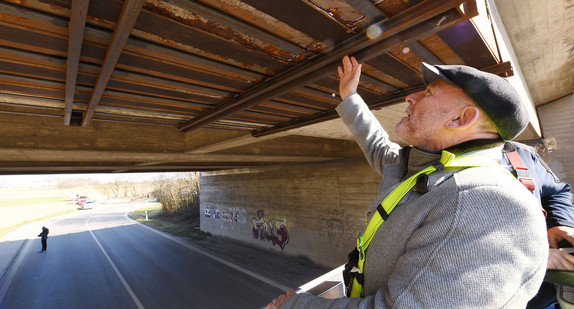 Verkehrsminister Hermann begutachtet den Schaden an einer Brücke.