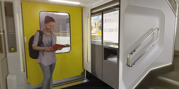 Bahn Neue Doppelstockzüge von Alstom Eine Frau steht im Innenraum eines Doppelstockzuges im Türbereich und liest eine Zeitung.