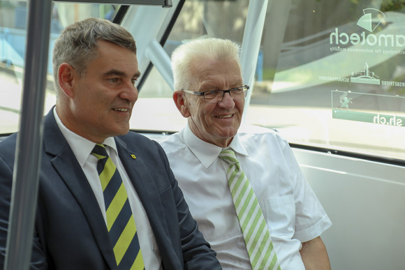 Delegationsreise Kretschmann besucht die Schweiz Ministerpräsident Winfried Kretschmann (r.) und Christian Amsler (l.), Regierungspräsident des Kantons Schaffhausen, sitzen in einem autonom fahrenden Bus der Verkehrsbetriebe Schaffhausen.