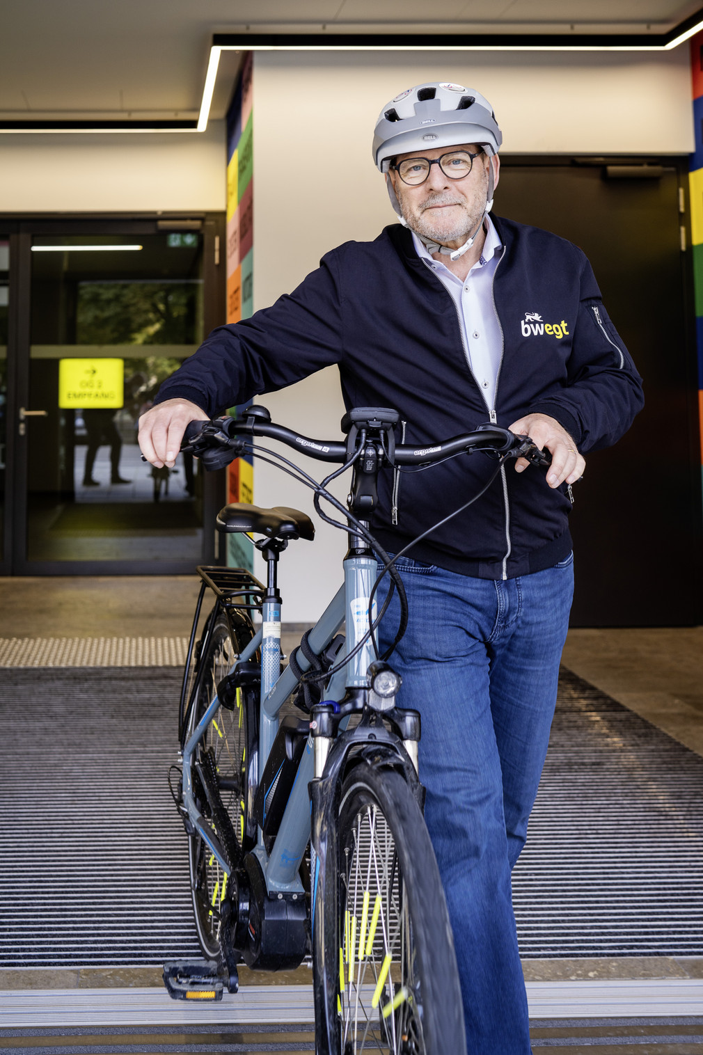Verkehrsminister Winfried Hermann trägt einen Fahrradhelm und schiebt sein Fahrrad aus dem Verkehrsministerium.
