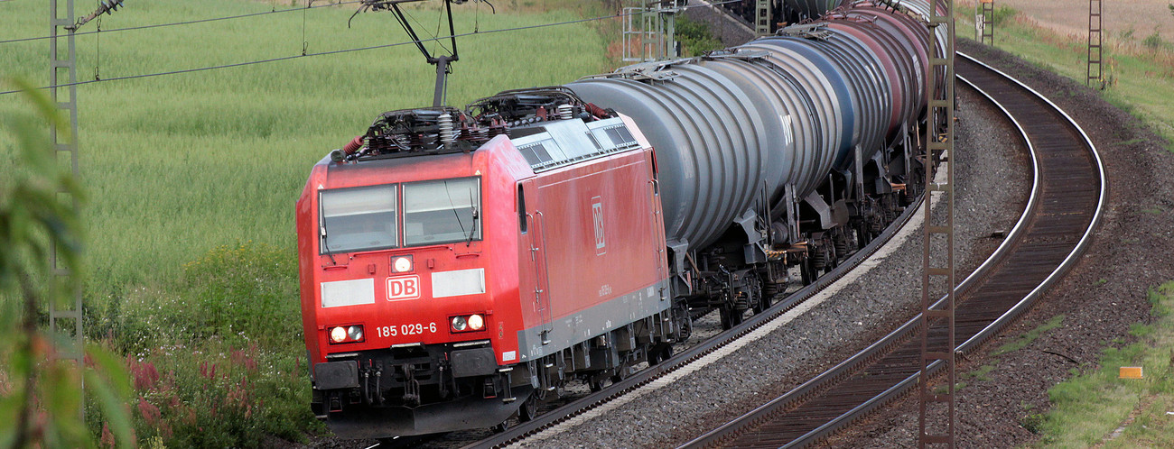 Güterzug mit mehreren Waggons fährt auf den Gleisen vorbei