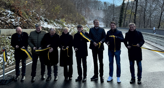 Menschen schneiden bei der symbolischen Verkehrsfreigabe auf der Gönninger Steige ein Band durch. 