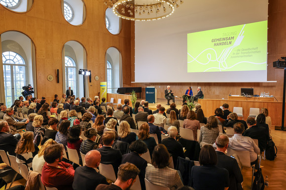 Zusammenhalt in der Transformation Tagung „Gemeinsam handeln“ Blick in der Aula der Universität Mannheim während des Podiumsgesprächs mit dem ehemaligen Bundespräsidenten Joachim Gauck und Ministerpräsident Winfried Kretschmann im Rahmen der Tagung „Gemeinsam handeln – die Gesellschaft in der Transformation zusammenhalten“.