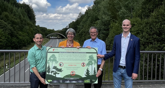 Frau Staatssekretärin Elke Zimmer steht gemeinsam mit einem Verbotsschild vor einer Grünbrücke bei Böblingen. 