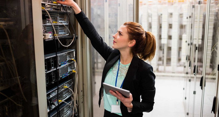 Technikerin hält digitales Tablet während der Untersuchung des Servers