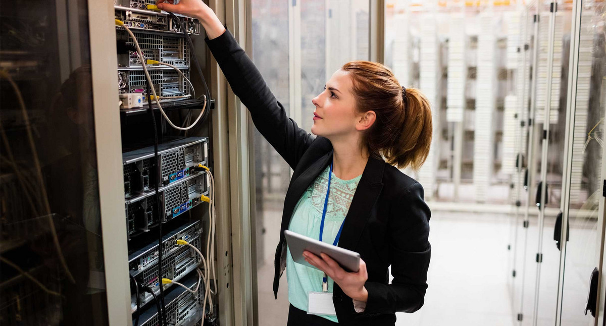 Technikerin hält digitales Tablet während der Untersuchung des Servers