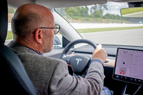 Elektromobilität e4 TESTIVAL auf dem Hockenheimring Verkehrsminister Winfried Hermann MdL bei der Probefahrt im Tesla Model 3 beim e4 TESTIVAL 2019 (Bilderquelle: Kira Chaparro_© emodrom)