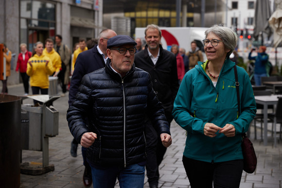 Ein Mann und eine Frau laufen nebeneinander durch eine Fußgängerzone.