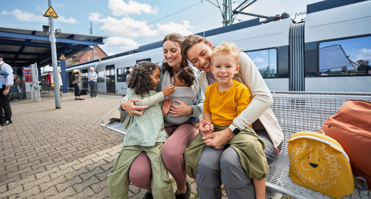 Familie wartet an Haltestelle