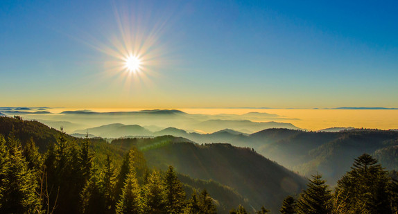 Sonnenaufgang über einer bergigen Landschaft im Schwarzwald.  