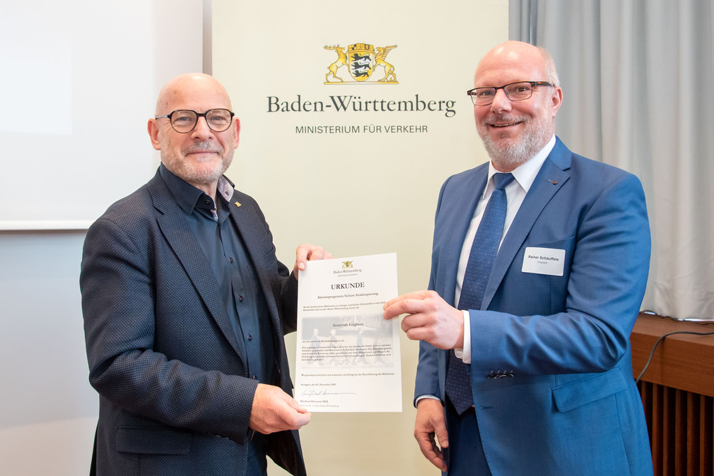 Winfried Hermann überreicht die Urkunde Bürgermeister Rainer Schäuffele der Gemeinde Erligheim.