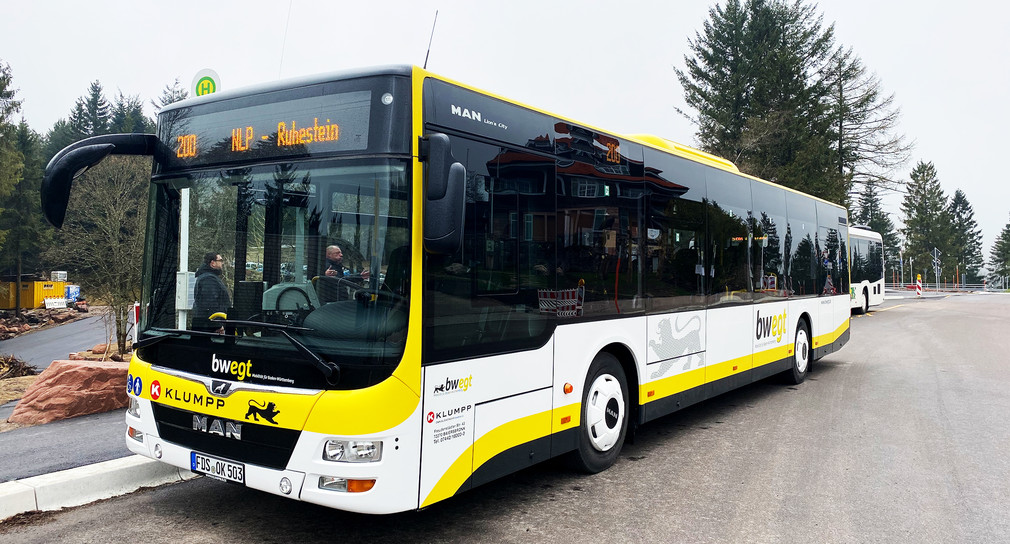 Ein gelb-weißer Regiobus im Nationalpark Schwarzwald steht an einer Bushaltestelle.