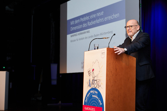 RAD Auf dem Weg zum Pedelec-Land - RadKONGRESS BW 2019 Minister Winfried Hermann auf Bühne hinter Rednerpult