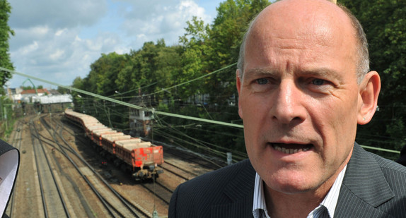 Verkehrsminister Winfried Hermann auf einer Brücke über die Rheintalbahn in  Offenburg (Bild: © dpa).