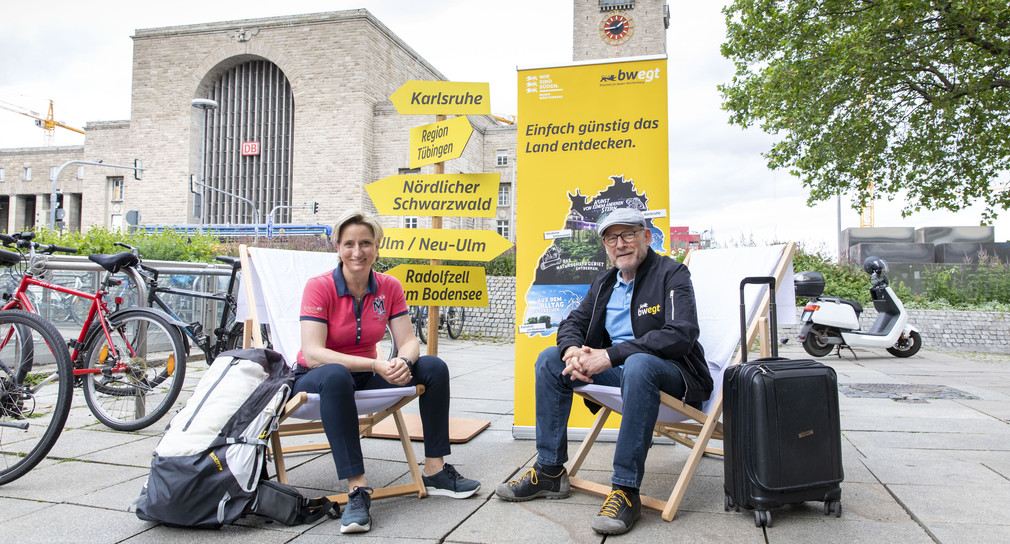 Tourismusministerin Dr. Nicole Hoffmeister-Kraut und Verkehrsminister Winfried Hermann sitzen in Liegesühlen vor dem Stuttgarter Hauptbahnhof. 