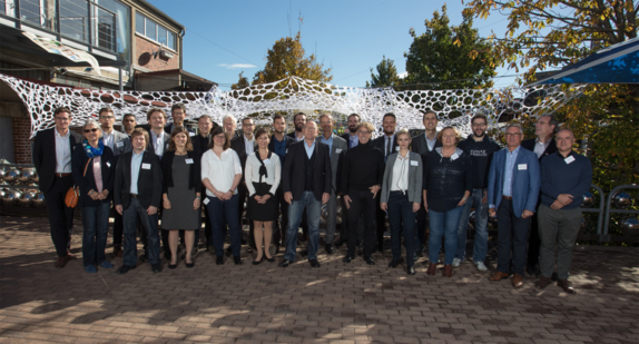 Mehrere Menschen stehen zu einem Gruppenbild zusammen.