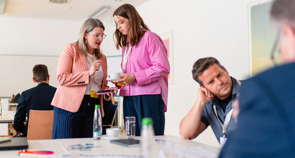 Zwei Frauen stehen zusammen und sprechen miteinander.