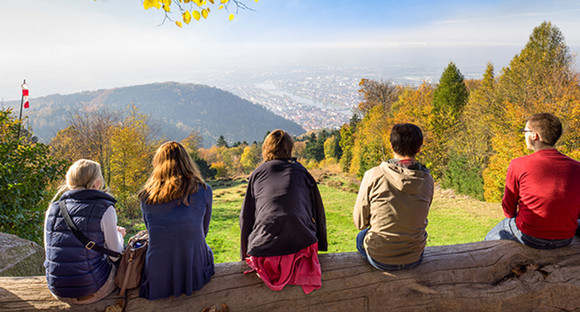 Mehrere Menschen blicken vom Königstuhl auf Heidelberg und die Rheinebene (Bild: Fotolia.com)