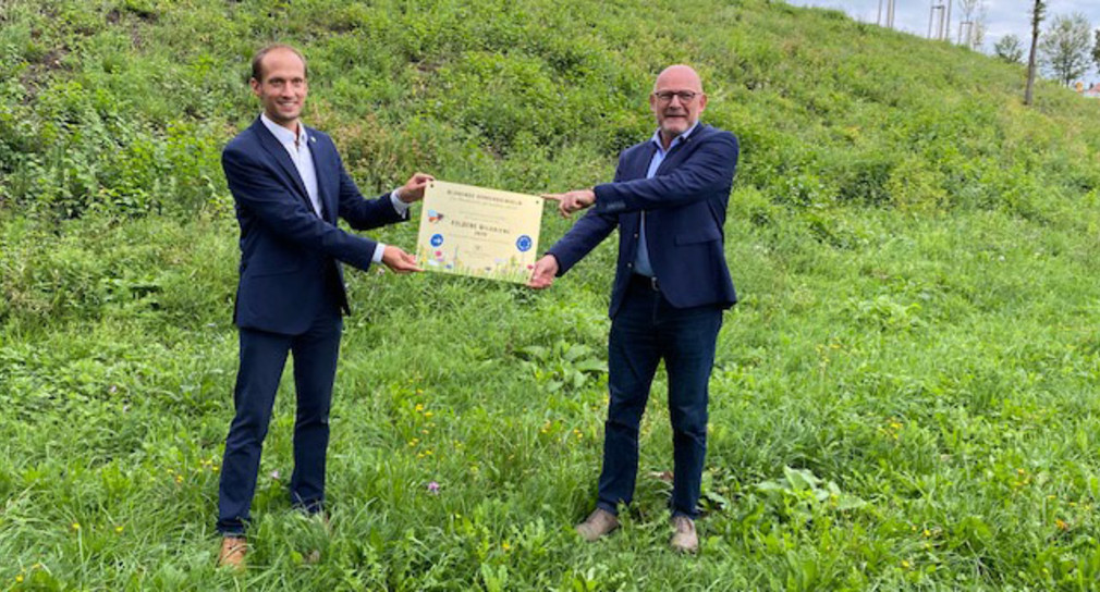 Verkehrsminister Winfried Hermann und der Crailsheimer Oberbürgermeister Dr. Christoph Grimmer präsentieren gemeinsam die Auszeichnung "Goldene Wildbiene"