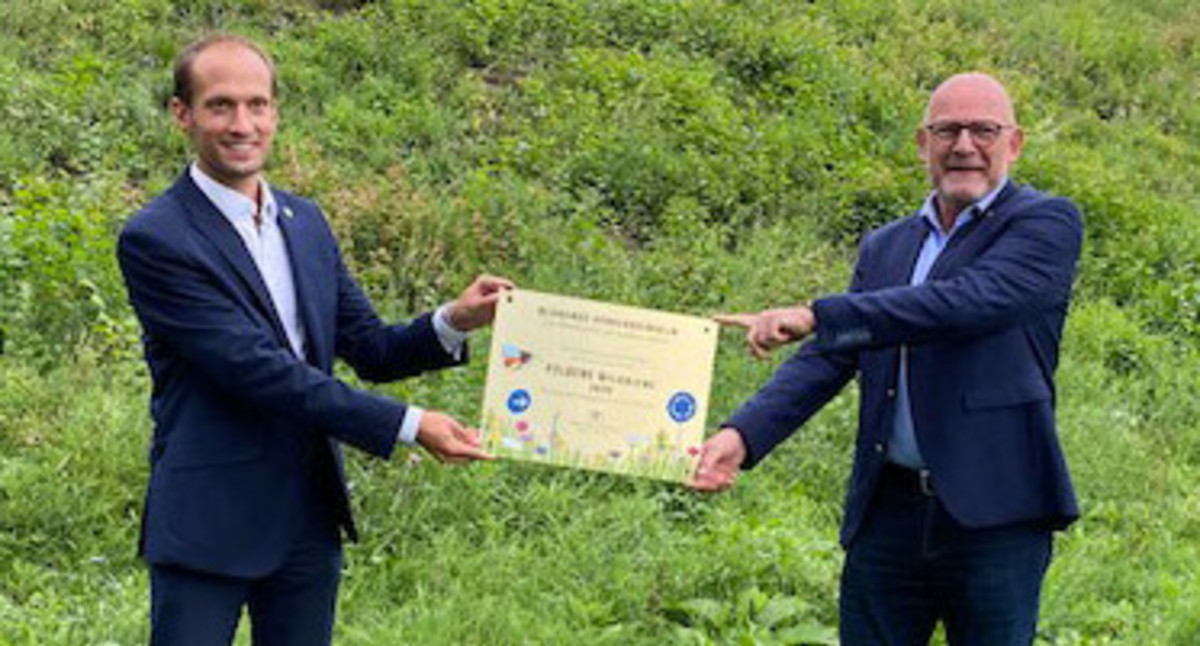 Verkehrsminister Winfried Hermann und der Crailsheimer Oberbürgermeister Dr. Christoph Grimmer präsentieren gemeinsam die Auszeichnung "Goldene Wildbiene"